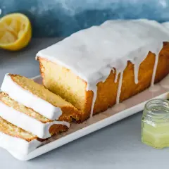 Saftiger Zitronenkuchen mit Zuckerguss, perfekt für ein einfaches zitronenkuchen rezept. Serviert mit frischen Zitronenscheiben.