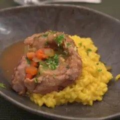 Ein köstliches Ossobuco-Rezept: zartes Kalbfleisch in Sauce mit Karotten und Sellerie, serviert auf cremigem Safranrisotto.
