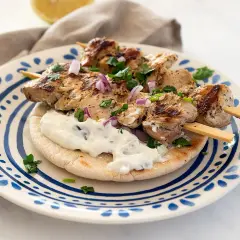 Saftige Hähnchen-Souvlaki-Spieße auf Pitabrot mit Tzatziki und roten Zwiebeln. Ein köstliches Souvlaki Rezept für den Sommer.