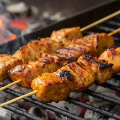 Saftige Hähnchenspieße garen über glühender Kohle. Ein perfektes Schaschlik Rezept für den Sommer.
