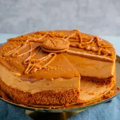 Ein köstlicher Lotus Kuchen mit Mascarpone, dekoriert mit Karamell und Kekskrümeln. Ein Stück fehlt bereits.