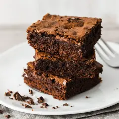 Gestapelte, saftige Brownies auf einem Teller, bereit zum Genießen. Ein perfektes brownie rezept für Schokoladenliebhaber.