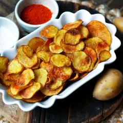 Selbstgemachte Kartoffelchips, goldbraun und knusprig, mit Paprikapulver und Salz. So einfach kannst du Chips selber machen!