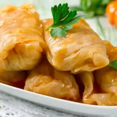 Kohlrouladen mit Hackfleisch in Sauce auf einem Teller, garniert mit Petersilie.