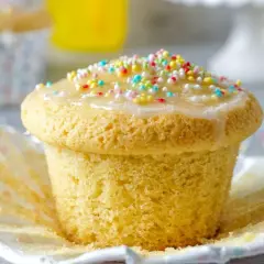 Ein leckerer Muffin mit Zuckerguss und bunten Streuseln, perfekt für einen Kindergeburtstag.