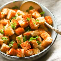 Goldbraune, knusprige Croutons mit Petersilie garniert, perfekt zum Salat. So einfach kannst du Croutons selber machen!