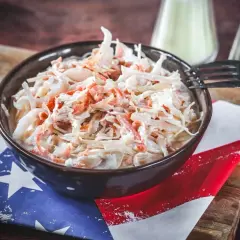 Schüssel mit cremigem Krautsalat, perfekt für Ihr coleslaw rezept. Ein Gabel liegt bereit.