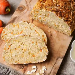 Frisch gebackenes Karottenbrot mit Haferflocken, perfekt für das brot backen im airfryer. Dazu Butter und ganze Karotten.