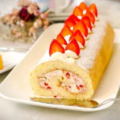 Ein köstliches Biskuitrolle Rezept mit frischen Erdbeeren und Sahne, bestäubt mit Puderzucker. Perfekt für jeden Anlass!