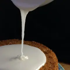 Zuckerguss Rezept: Ein Kuchen wird mit flüssigem Zuckerguss überzogen.