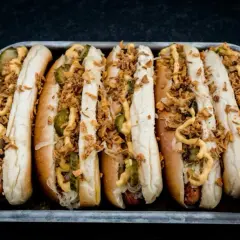 Sechs appetitliche Hotdogs mit Sauerkraut, Gurken, Senf und knusprigen Zwiebeln. Ein perfektes Hotdog Rezept für jeden Anlass.