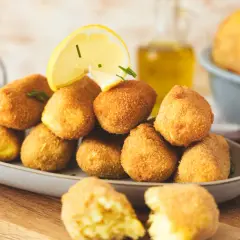 Goldbraune, knusprige Kroketten, frisch zubereitet, mit Zitrone und Kräutern garniert. Perfekt zum Selbermachen!
