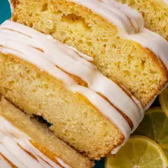 Saftiger zitronenkuchen mit Joghurt, überzogen mit süßer Glasur und garniert mit frischen Zitronenscheiben.