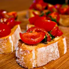 Frisch zubereitete Bruschetta mit Tomaten und Basilikum auf geröstetem Brot. Ein einfaches und leckeres bruschetta rezept.