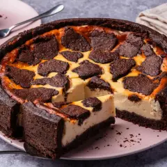 Ein saftiger russischer Zupfkuchen mit dunklem Schokoladenboden und cremiger Käsemasse, belegt mit zupfenden Schokoladenstückchen.