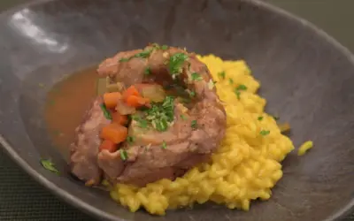 Ein köstliches Ossobuco-Rezept: zartes Kalbfleisch in Sauce mit Karotten und Sellerie, serviert auf cremigem Safranrisotto.