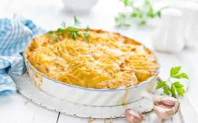 Kretanische Kartoffeln, goldbraun gebacken in einer Auflaufform, mit Knoblauch und Petersilie garniert. Ein Genuss!