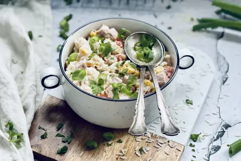 Ein cremiger Reis-Salat mit Hähnchen, Mais und Tomaten, garniert mit Frühlingszwiebeln und Petersilie. Perfekt für ein leichtes Mittagessen.