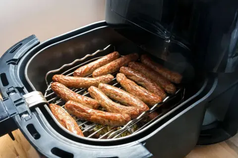 Luftfritteuse mit vielen Bratwürsten, perfekt für schnelle Bratwurst Rezepte.