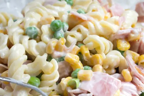 Cremiger Nudelsalat mit Schinken, Erbsen und Mais. Ein einfaches nudelsalat rezept für jede Gelegenheit.