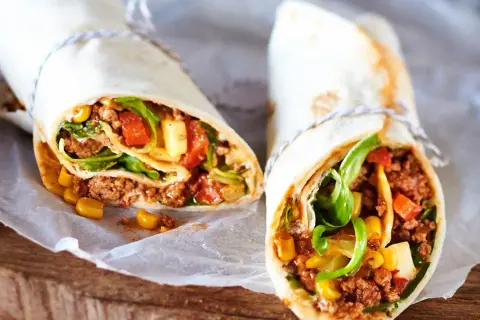 Zwei leckere wraps mit hackfleisch, Mais, Tomaten und Salat. Perfekt für eine schnelle Mahlzeit.