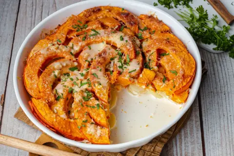 Herzhafte Hokkaido-Rezepte: Cremiger Auflauf mit Kürbis und Käse, garniert mit Petersilie. Ein Genuss für kalte Tage.