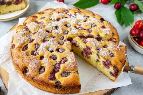 Saftiger Kirschkuchen, perfekt für das Kirschkuchen Rezept. Mit Puderzucker bestäubt und voller Kirschen.