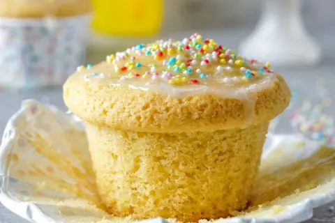 Ein leckerer Muffin mit Zuckerguss und bunten Streuseln, perfekt für einen Kindergeburtstag.
