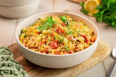 Ein klassisches Couscous-Salat Rezept, frisch zubereitet mit Tomaten, Gurken, Paprika und Kräutern, garniert mit Petersilie.