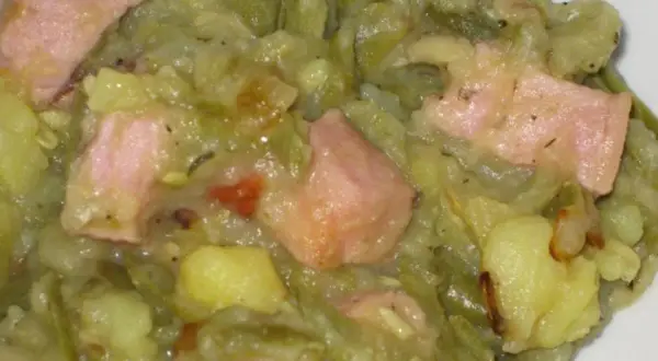 Ein deftiger Eintopf mit sauren Bohnen, Kartoffeln und rosa Speckstücken.