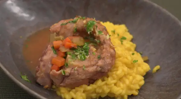 Ein köstliches Ossobuco-Rezept: zartes Kalbfleisch in Sauce mit Karotten und Sellerie, serviert auf cremigem Safranrisotto.