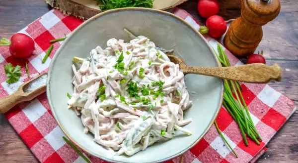 Schmackhaftes Fleischsalat Rezept, garniert mit frischen Kräutern. Dazu Radieschen, Salz und ein Pfeffermühlen-Set.
