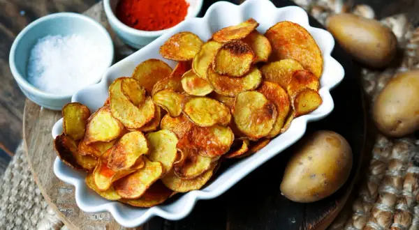 Selbstgemachte Kartoffelchips, goldbraun und knusprig, mit Paprikapulver und Salz. So einfach kannst du Chips selber machen!