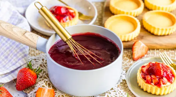 Frisch zubereiteter Tortenguss mit Erdbeeren und leeren Tartelettes. So einfach lässt sich Tortenguss selber machen!