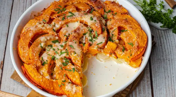 Herzhafte Hokkaido-Rezepte: Cremiger Auflauf mit Kürbis und Käse, garniert mit Petersilie. Ein Genuss für kalte Tage.