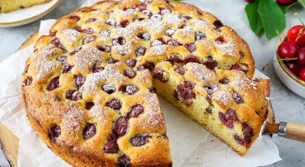 Saftiger Kirschkuchen, perfekt für das Kirschkuchen Rezept. Mit Puderzucker bestäubt und voller Kirschen.