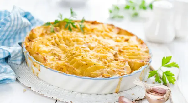 Kretanische Kartoffeln, goldbraun gebacken in einer Auflaufform, mit Knoblauch und Petersilie garniert. Ein Genuss!