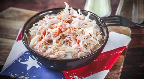 Schüssel mit cremigem Krautsalat, perfekt für Ihr coleslaw rezept. Ein Gabel liegt bereit.