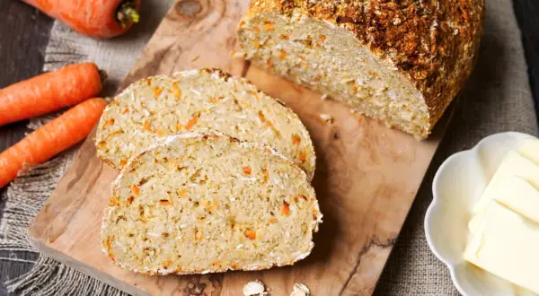 Frisch gebackenes Karottenbrot mit Haferflocken, perfekt für das brot backen im airfryer. Dazu Butter und ganze Karotten.
