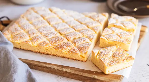 Leckerer Blechkuchen mit Puderzucker bestreut, perfekt für einfache Blechkuchen Rezepte.