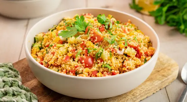 Ein klassisches Couscous-Salat Rezept, frisch zubereitet mit Tomaten, Gurken, Paprika und Kräutern, garniert mit Petersilie.