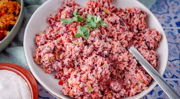 Bunter Karottensalat, frisch zubereitet im Thermomix, garniert mit Petersilie. Daneben eine Schale mit Dip.