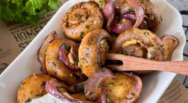 Gefüllte Champignons mit roten Zwiebeln, perfekt aus dem Airfryer, serviert mit Dip.
