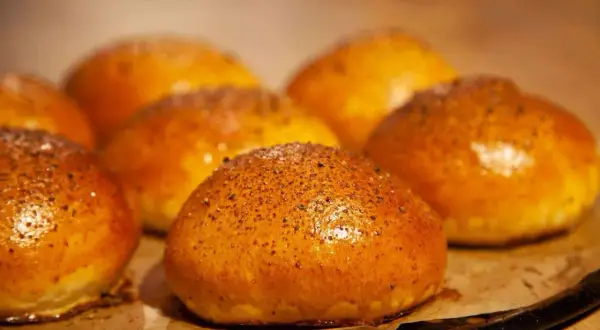 Frisch gebackene Burger-Buns, bereit, um den perfekten Burger selber machen zu können. Goldbraun und mit Sesam bestreut.