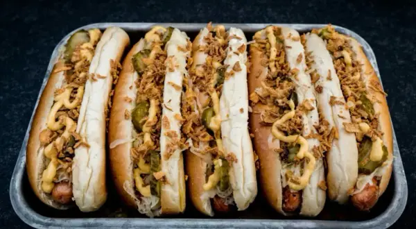 Sechs appetitliche Hotdogs mit Sauerkraut, Gurken, Senf und knusprigen Zwiebeln. Ein perfektes Hotdog Rezept für jeden Anlass.
