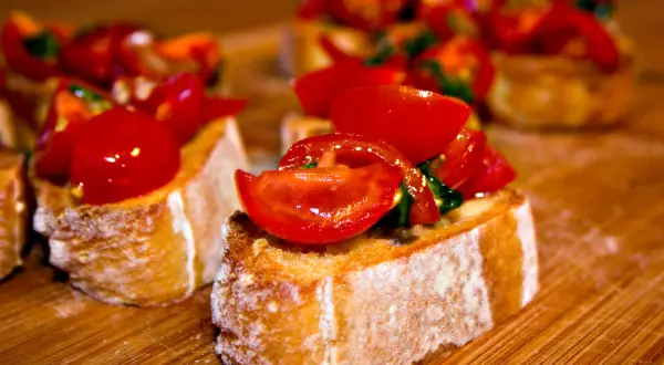 Frisch zubereitete Bruschetta mit Tomaten und Basilikum auf geröstetem Brot. Ein einfaches und leckeres bruschetta rezept.