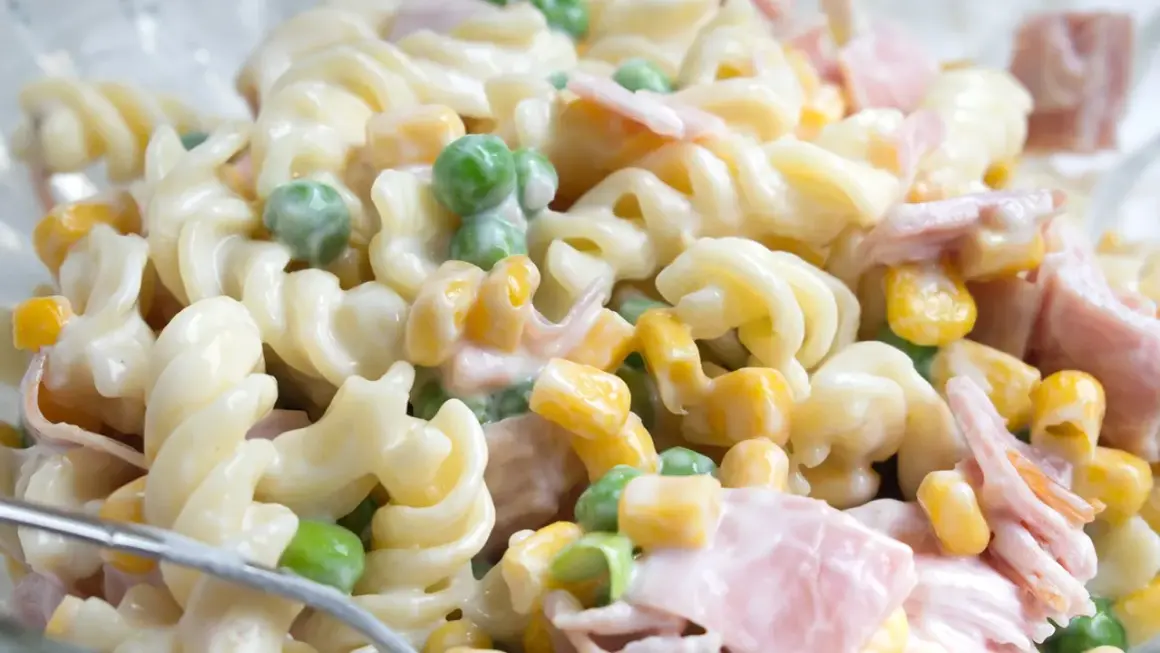 Cremiger Nudelsalat mit Schinken, Erbsen und Mais. Ein einfaches nudelsalat rezept für jede Gelegenheit.