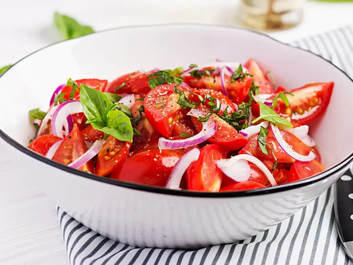 Frischer Tomatensalat mit roten Zwiebeln und Basilikum. Ein einfaches und leckeres tomatensalat rezept für den Sommer.