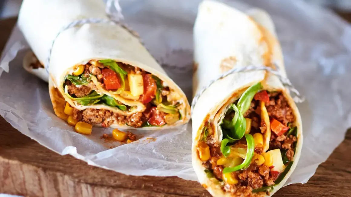 Zwei leckere wraps mit hackfleisch, Mais, Tomaten und Salat. Perfekt für eine schnelle Mahlzeit.
