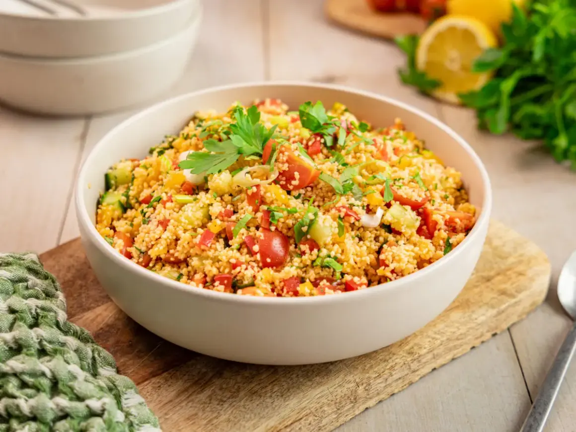 Ein klassisches Couscous-Salat Rezept, frisch zubereitet mit Tomaten, Gurken, Paprika und Kräutern, garniert mit Petersilie.